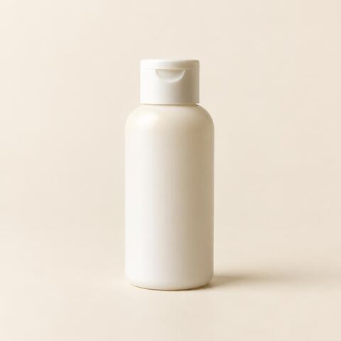 An unlabeled travel-size shampoo bottle with a flip cap